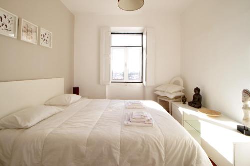 リスボンにあるRita & Marino Apartmentの白いベッドルーム(大型ベッド1台、窓付)