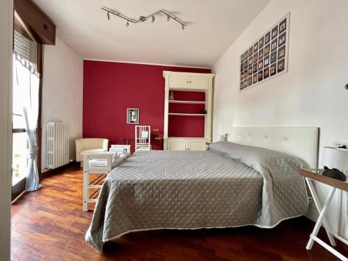 a bedroom with a bed and a red wall at Soliera 105 - Appartamento su due livelli in zona tranquilla in Soliera