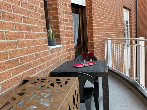 a black table and chair on a balcony at Soliera 105 - Appartamento su due livelli in zona tranquilla in Soliera