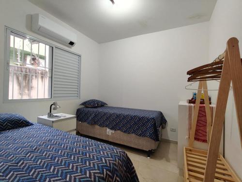una camera da letto con due letti e una finestra di Casa de 3 quartos com ares-condicionados a Campo Grande