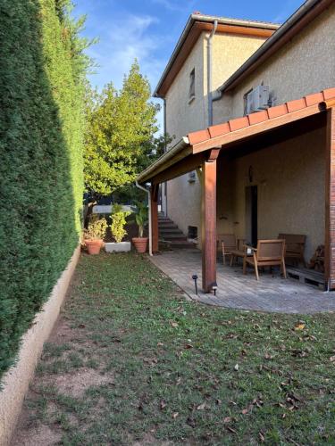 a patio with a table and a bench in front of a house at Studio équipé avec Parking Le Chasseland in Chassieu