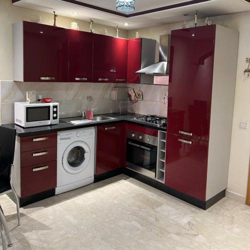 a kitchen with a washing machine and a microwave at Marrakech Family Stay City Center in Marrakech