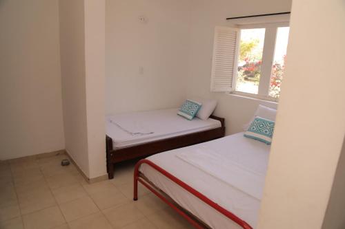 a small room with two beds and a window at Club Camping Islamar in Baru