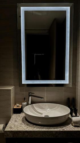 a bathroom sink with a large mirror above it at Premier Suites Twin Towers at Star Residences in Kuala Lumpur