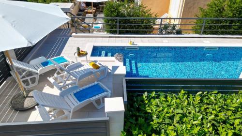 una piscina con lettini e un ombrellone di Villa "Amber" relaxation in nature with a Pool a Mlini