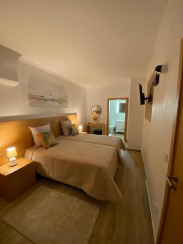 a bedroom with a large bed and a doorway at Vivenda Por do Sol in Couço