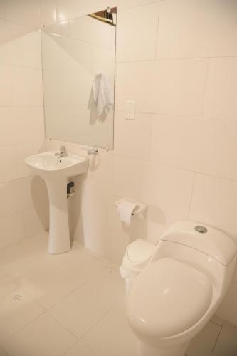 a white bathroom with a toilet and a sink at Club Camping Islamar in Baru