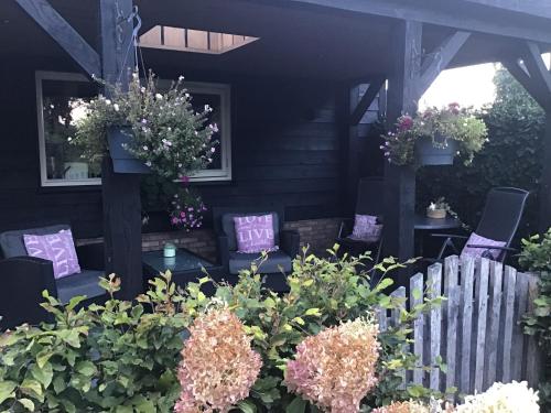 a garden with flowers and plants in front of a house at Vakantiehuisje B&B de Kleine Voskuil in Hulshorst