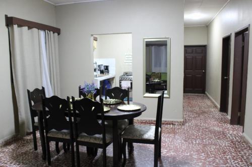 a dining room with a black table and chairs at Casa Efra 3 hab 2 baños in Tela