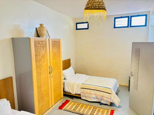 a bedroom with a bed and a dresser in it at Sunrise Camp in Mirleft