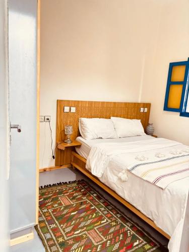 a bedroom with a bed and a rug at Sunrise Camp in Mirleft