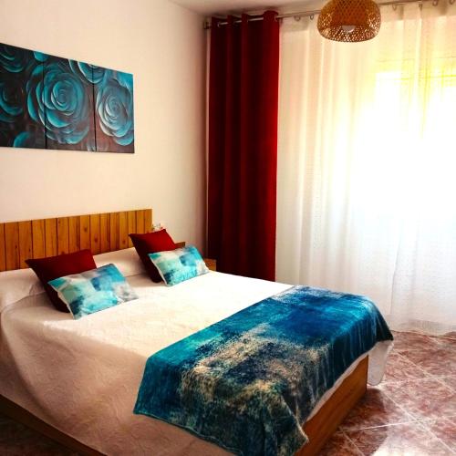 a bedroom with a bed with a blue blanket on it at Casa Dulce Romero in Rute