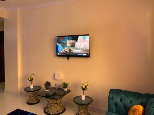 a living room with a flat screen tv on the wall at Anny's bnb in Ngong