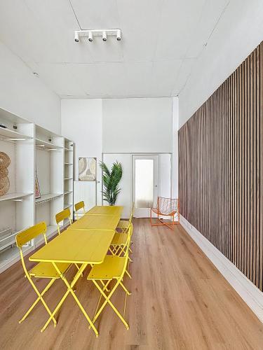 Una mesa y sillas amarillas en una habitación vacía. en Central Spot - Louise, en Bruselas