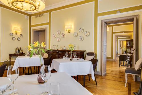 a restaurant with two tables and chairs and a chandelier at Castello La Leccia in Castellina in Chianti