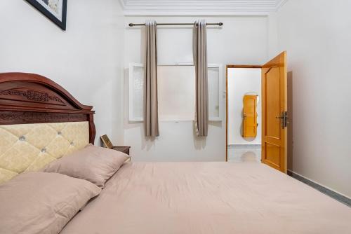 a bedroom with a bed with a wooden headboard at Dar Ourika - Mountain Views in Ourika