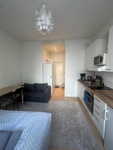 a kitchen and living room with a bed and a couch at Prime CityNest in Helsinki