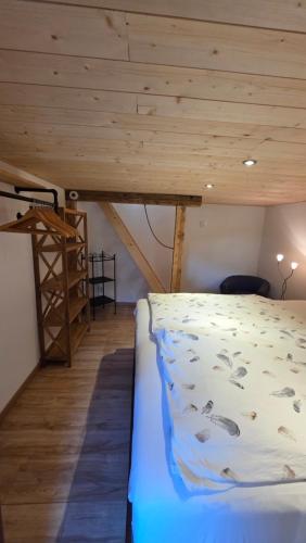 a bed in a room with a wooden ceiling at Lonys Wanderlust Nahe Zermatt in Sankt Niklaus