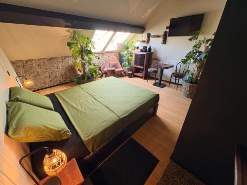 a bedroom with a large bed and plants in it at Casa Verde in Bruges