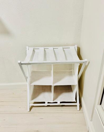 a white shelf in a corner of a room at 1 Bedroom Mini Apartment 10 Minutes to SeaTac Airport 1 Minute Walk to Bus Station in Seattle