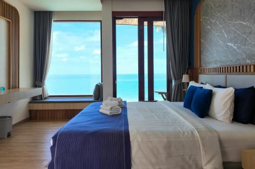 a hotel room with a bed with towels on it at เดอะซีน คาบาน่า บีช รีสอร์ท ขนอม The Scene Cabana Beach Resort Khanom in Ban Plau