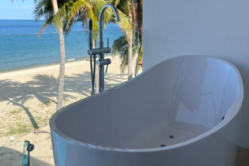 a white table with a view of the beach at เดอะซีน คาบาน่า บีช รีสอร์ท ขนอม The Scene Cabana Beach Resort Khanom in Ban Plau