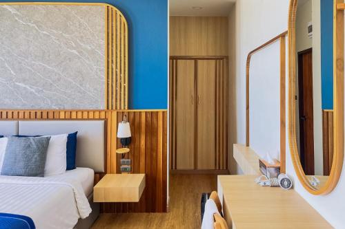 a hotel room with a bed and a mirror at เดอะซีน คาบาน่า บีช รีสอร์ท ขนอม The Scene Cabana Beach Resort Khanom in Ban Plau