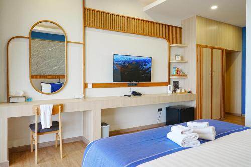 a bedroom with a blue bed and a mirror at เดอะซีน คาบาน่า บีช รีสอร์ท ขนอม The Scene Cabana Beach Resort Khanom in Ban Plau