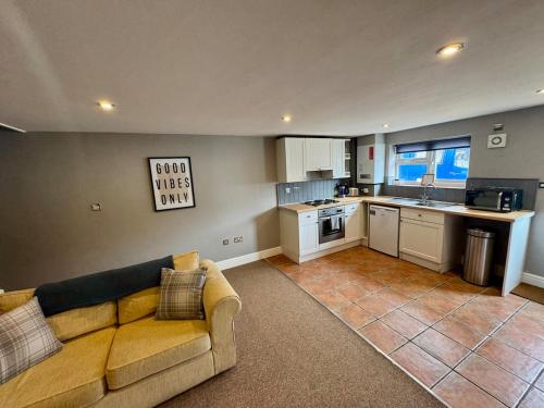 ein Wohnzimmer mit Couch und Küche in der Unterkunft Sunset Cottage in Hunstanton