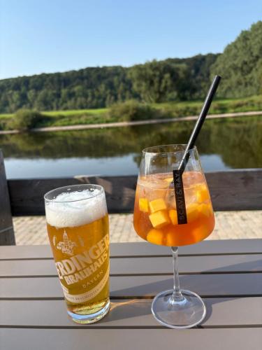 two glasses of beer on a table with a view of a lake at RelaxStay - Weserbergland in Heinsen