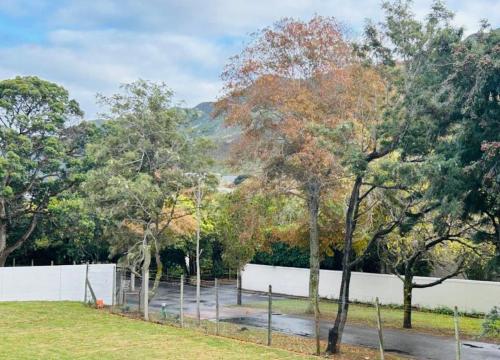 a park with trees and a white fence at Valley's Embrace Apartment 7 in Hermanus