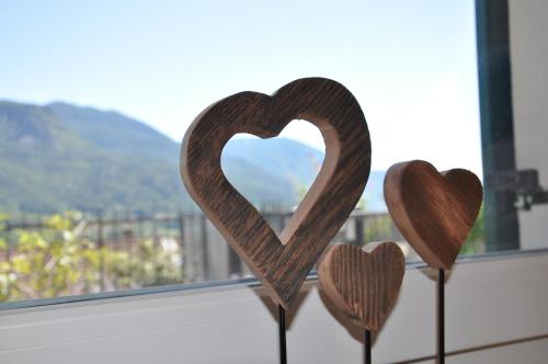three wooden hearts sitting on a window sill at Il fiore del Calisio in Trento
