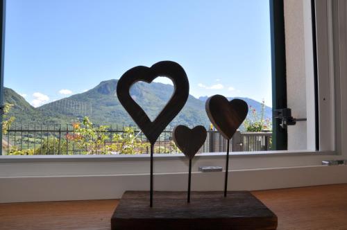 two wooden hearts on sticks in front of a window at Il fiore del Calisio in Trento