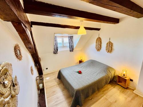 a bedroom with a bed in a room with wooden beams at Gîtes Montvaltin - Appartement spacieux 3 chambres & cuisine in Le Breuil
