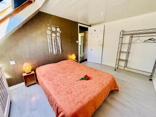 a bedroom with a red bed with a red flower on it at Gîtes Montvaltin - Appartement spacieux 3 chambres & cuisine in Le Breuil