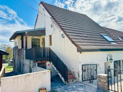 a white house with a black roof at Gîtes Montvaltin - Appartement spacieux 3 chambres & cuisine in Le Breuil