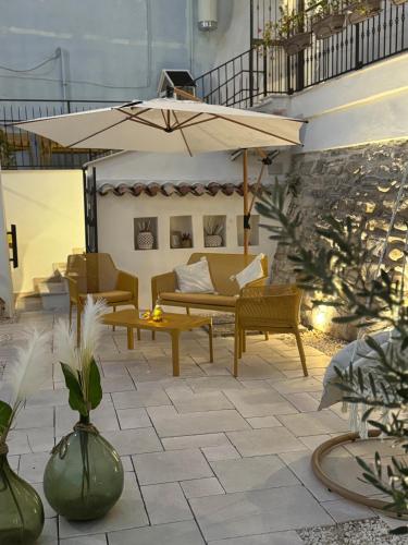 a patio with a couch and an umbrella at Les Petites Maisons in Rodi Garganico