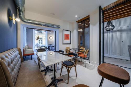 a living room with a couch and tables and chairs at Homely Málaga Mariblanca 17, Vegafuente Apartments in Málaga