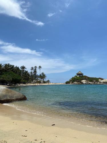a beach with a group of people in the water at Eco Hotel Amanecer Tayrona in El Zaino