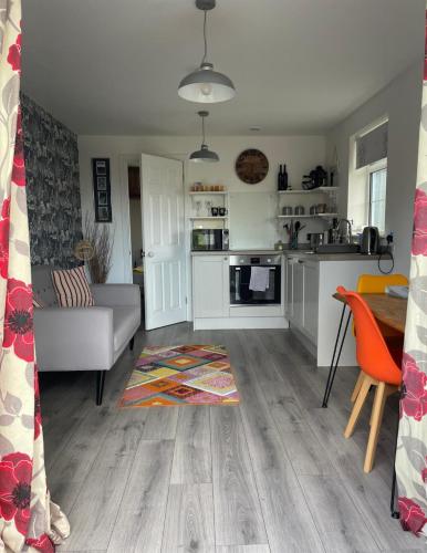a living room with a couch and a kitchen at Loughor Annnex, Llangennech , Wales in Llangennech