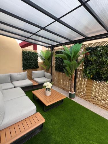 a patio with a couch and a table and green grass at Sunny apartment la huerta in Alicante