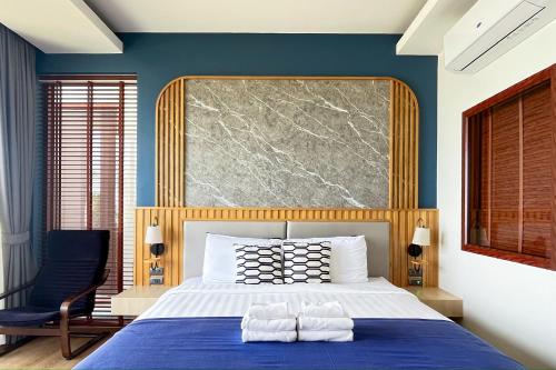 a blue bedroom with a bed with two towels on it at เดอะซีน คาบาน่า บีช รีสอร์ท ขนอม The Scene Cabana Beach Resort Khanom in Ban Plau