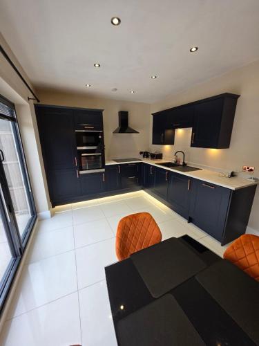 a kitchen with black cabinets and orange chairs in it at The City Haven Near City Centre in York