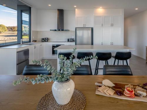 a kitchen with a table with a vase with flowers at Cove Landing Marina Apartments CL01-Apt:1,2,3 Sleeps 12 in Penneshaw