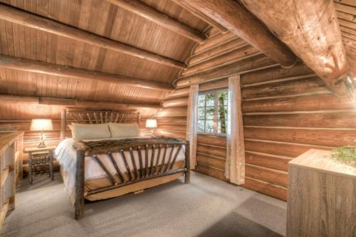 a bedroom with a bed in a log cabin at LOGE Alta Crystal in Enumclaw