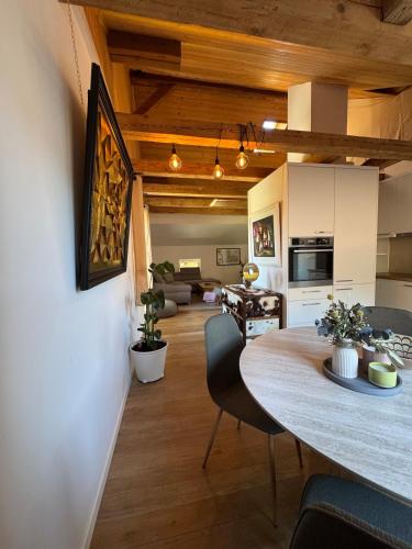 a kitchen and dining room with a table and a living room at Comfy, Spacious and Central Duplex Apartment in Zweisimmen