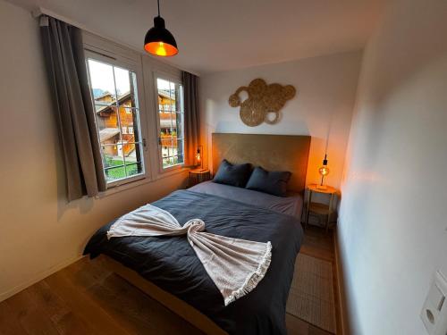 un dormitorio con una cama y una ventana en Comfy, Spacious and Central Duplex Apartment, en Zweisimmen
