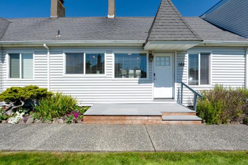 a white house with a porch and a door at The Tides by the Sea in Seaside