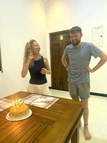 a man and a woman standing next to a table with a birthday cake at Sahan Tourist House in Polonnaruwa