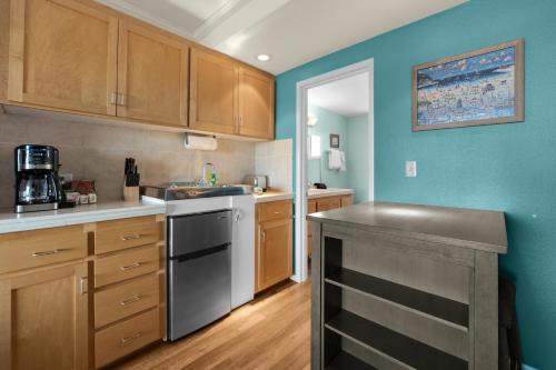 a kitchen with blue walls and wooden cabinets at The Tides by the Sea in Seaside
